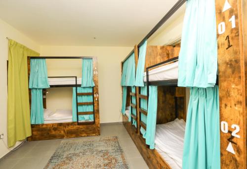 阿布扎比The Villa Hostel Abu Dhabi的配有蓝色窗帘的客房内的两张双层床