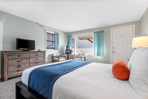 约克海滩The Lighthouse Inn & Suites的一间卧室配有一张大床和电视