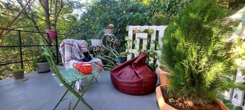 库塔伊西Cottage lima的阳台种植了植物,配有椅子和钱包