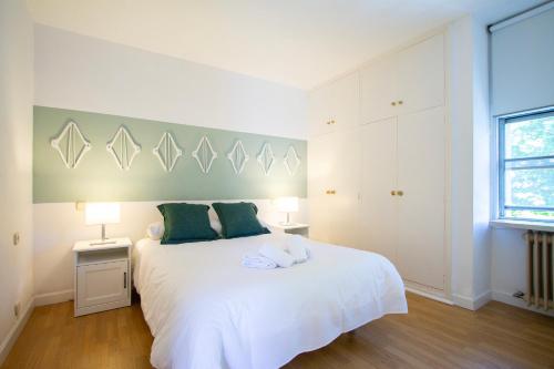 马德里托斯卡德科公寓的卧室配有带绿色枕头的白色床