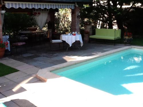 图卢兹运河别墅住宿加早餐旅馆的一个带桌子、桌子和桌子的游泳池