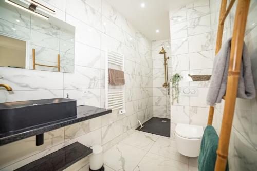 凡尔赛Lovely Apartment Palace of Versailles的白色的浴室设有水槽和卫生间。