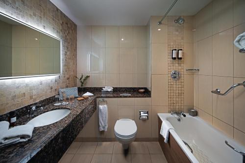 柯罗格伦都柏林机场卡尔顿酒店的浴室配有盥洗盆、卫生间和浴缸。