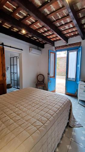 查斯科穆斯La Botica de 1852 Hotel的一间卧室设有一张大床和蓝色的门