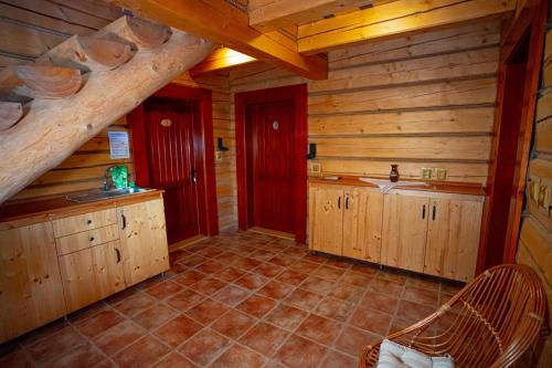 NižnáPenzion Oravsky Zrub的小屋内的厨房设有木制橱柜和楼梯