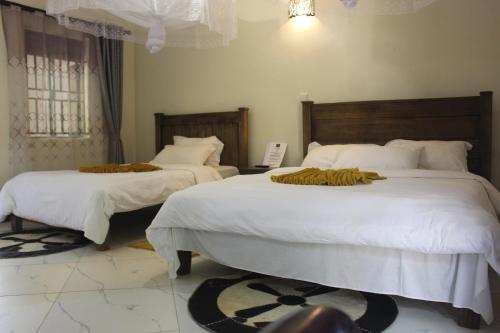 波特尔堡Montane Safaris Hotel的一间卧室配有两张带白色棉被的床