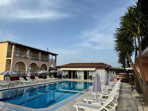 拉加纳斯Julias Apartments的一个带躺椅的游泳池和一间酒店