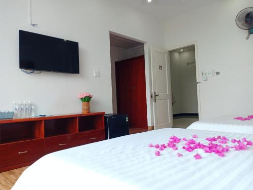 绥和市KHÁCH SẠN PHÚ YÊN - Khách sạn ven biển - trung tâm Tuy Hoà的一间卧室,床上有粉红色的鲜花