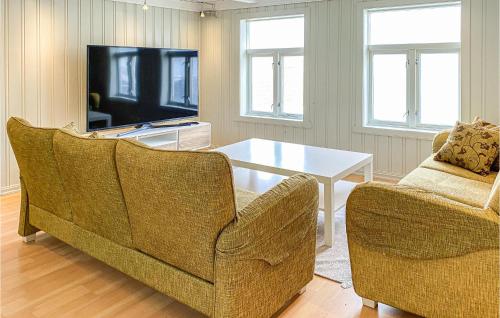 克里斯蒂安桑德Awesome Home In Kristiansund With House Sea View的客厅配有两把椅子、一张桌子和一台电视