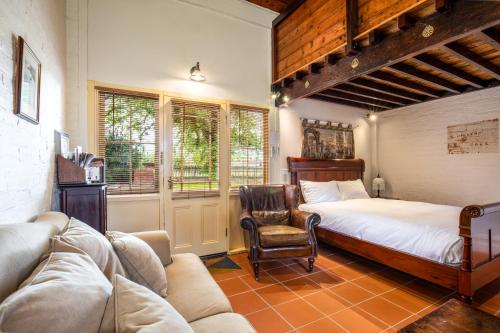 瑟尔Bon Accord Luxury Accommodation的一间卧室配有一张床、一把椅子和一张沙发