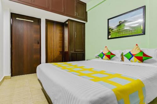 钦奈OYO Home G-cloud Near Thirumangalam Metro Station的卧室配有一张带彩色枕头的大型白色床。