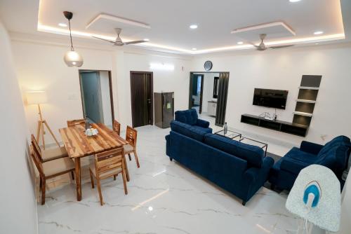 海得拉巴N Cube Serviced Apartments的客厅配有蓝色的沙发和桌子