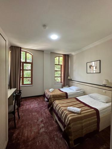第比利斯Hotel Europe plaza的酒店客房设有三张床和一张书桌