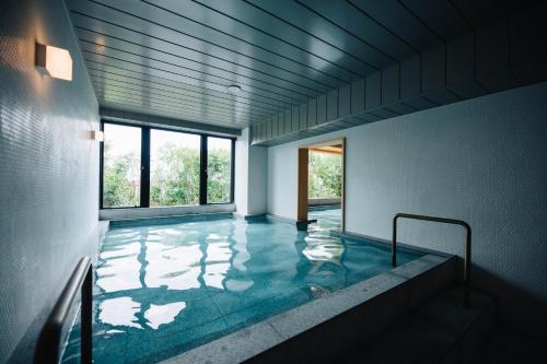 五岛Colorit GOTO ISLANDS的一间位于大楼内的客房,设有游泳池