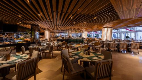 深圳深圳大梅沙京基洲际度假酒店 的一间带桌椅的餐厅和一间酒吧