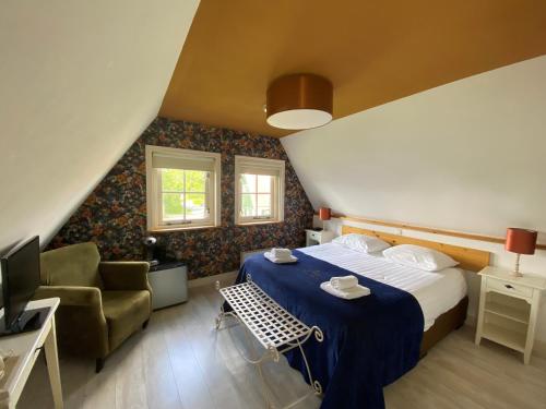 希波利蒂斯胡夫维林赫尔兰特休闲公园的一间卧室配有一张床、一把椅子和电视