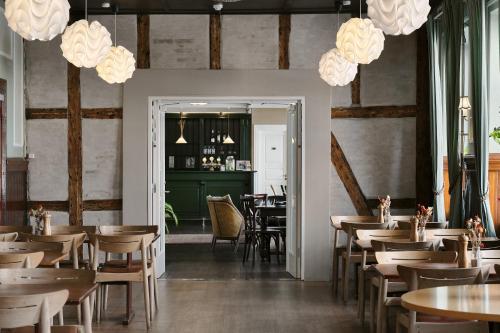斯文堡奥埃罗酒店的用餐室配有桌椅和吊灯。