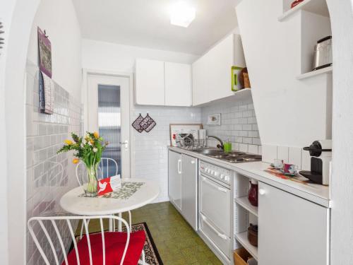 隆科索普拉阿斯科纳Studio Casa Schalom-1 by Interhome的厨房配有白色橱柜和鲜花桌