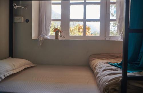 马拉里Hostelgia的一间卧室设有两张床和窗户。