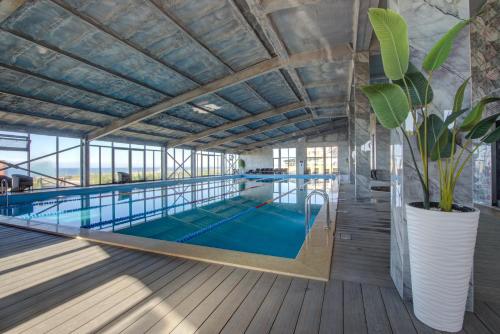 博斯特里Vzmorie Resort Hotel的大型室内游泳池,拥有大型天花板