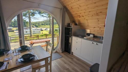 White BridgeGlengoulandie Glamping Pods的一间厨房,内设桌子和拱门