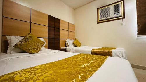 麦地那Basma Suites的酒店客房配有两张床和风扇