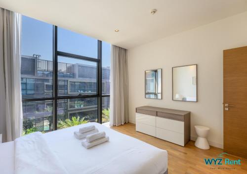 迪拜The perfect CityWalk 1 BR in the heart of Dubai的卧室设有白色的床和大窗户