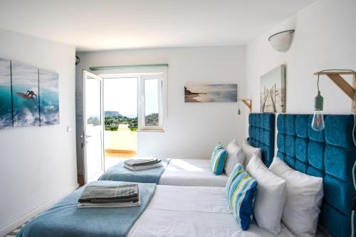 卢斯Mirabilia Luz - Altavista的一间卧室设有两张床和蓝色床头板
