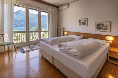 利莫内-苏尔加达玛格丽塔别墅酒店的一间卧室设有一张大床和大窗户