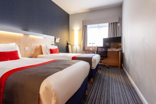 爱丁堡Holiday Inn Express Edinburgh – Royal Mile, an IHG Hotel的酒店客房配有两张床和一张书桌