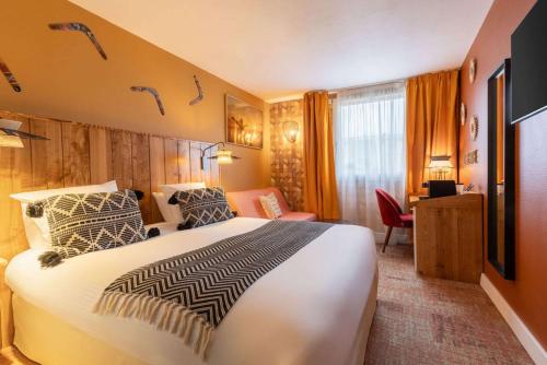 鲁瓦西昂法兰西Aiden by Best Western Paris Roissy CDG的酒店客房设有一张大床和一张书桌。