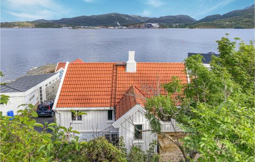 克里斯蒂安桑德Awesome Home In Kristiansund With House Sea View的白色的房子,有橙色的屋顶,靠近水体