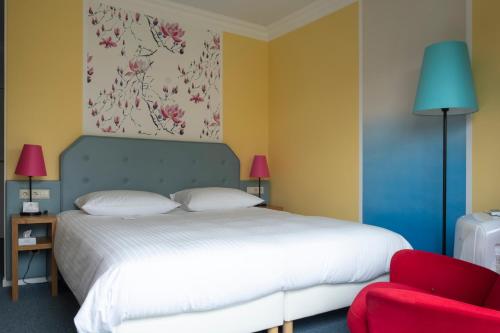 卢森堡卢森堡高瑞斯集团的一间卧室配有一张床和一张红色椅子