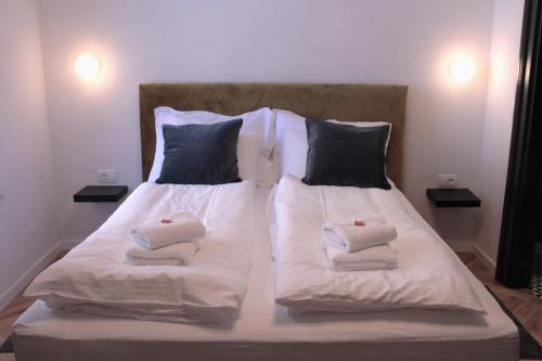 萨格勒布Zest and Nest Boutique Apartments的一张带白色毛巾和枕头的床