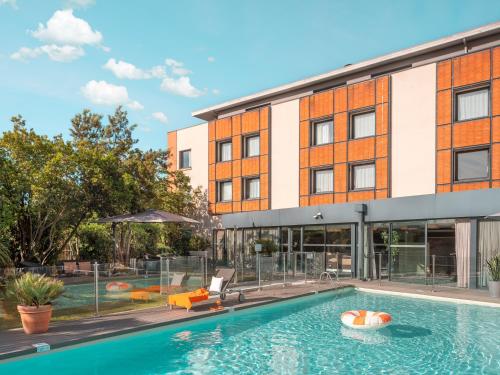 布拉尼亚克图卢兹机场智选假日酒店的享有带游泳池的建筑的外部景色