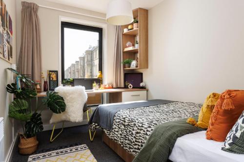 爱丁堡Unite Students - Chalmers Street - The Meadows的一间卧室配有一张床、一张书桌和一个窗户。