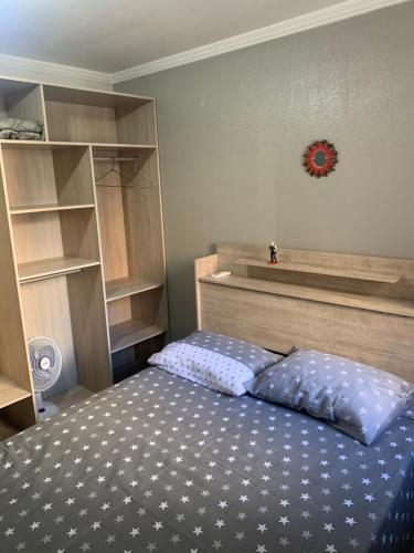 福塔莱萨Apartamento Porto de Iracema的卧室配有一张床,墙上挂着一个钟
