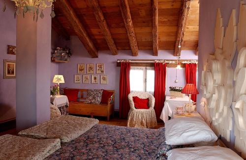 苏塞加纳马索迪平原乡村农舍的一间卧室配有红色窗帘、一张床和椅子