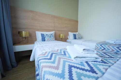 埃里温4Guest Hotel的一间卧室配有两张带毛巾的床