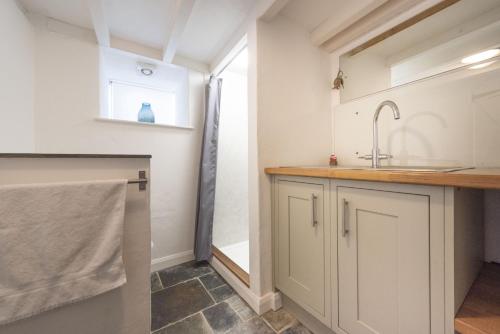 卡弗拉克Dolor Cottage的厨房配有白色橱柜和水槽