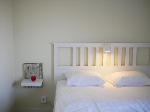 恩雪平Jädra Gårdshotel的一张带白色床单和枕头的床以及一盏灯