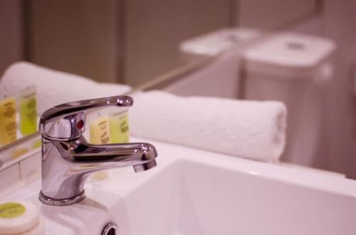 墨尔本布莱顿服务公寓式酒店的浴室水槽设有水龙头和镜子