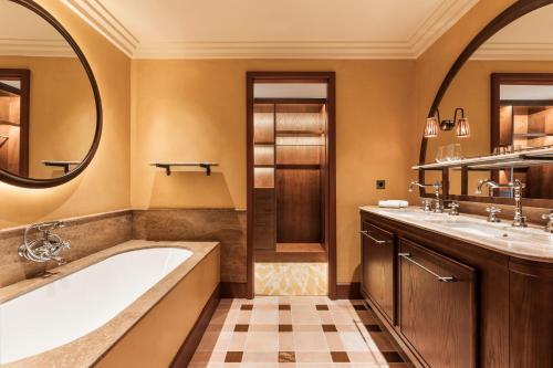 穆然卡蒂勒酒店的带浴缸、两个盥洗盆和镜子的浴室