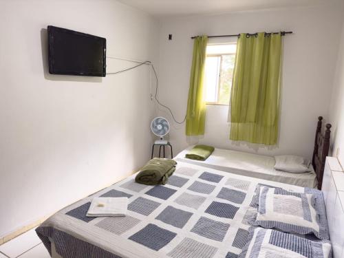 MatozinhosHotel Aconchego Matozinhos的一间卧室设有一张床、一台电视和一个窗口。
