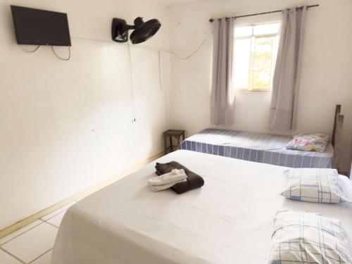 MatozinhosHotel Aconchego Matozinhos的一间卧室设有两张床,墙上配有电视。