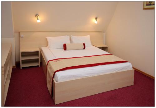 新西伯利亚科利柏酒店的一间卧室配有一张大床,铺有红地毯