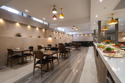 伊斯坦布尔Buke Hotel Bomonti的餐厅设有木桌、椅子和柜台