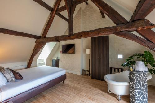 根特奥德伯根酒店的一间卧室设有一张大床和一个浴缸