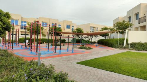 迪拜Damac Hills 2 Retreat- Tranquil Luxe, Beyond City with waterpark的大楼前的游乐场