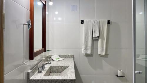 瓦索拉斯Mara Palace Hotel的白色的浴室设有水槽和镜子